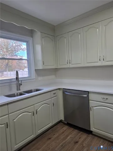 a kitchen with white cabinets and sink