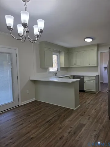a view of a room with wooden floor and kitchen view