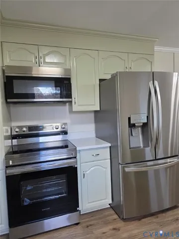 a kitchen with wooden cabinets and stainless steel appliances