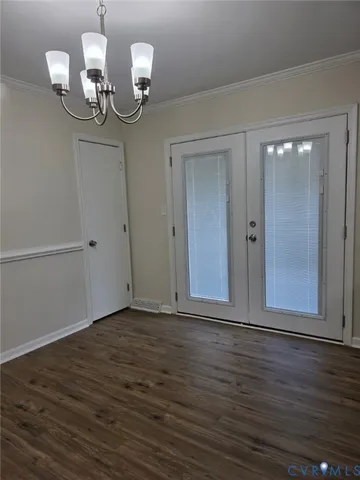 an empty room with wooden floor mirror and windows