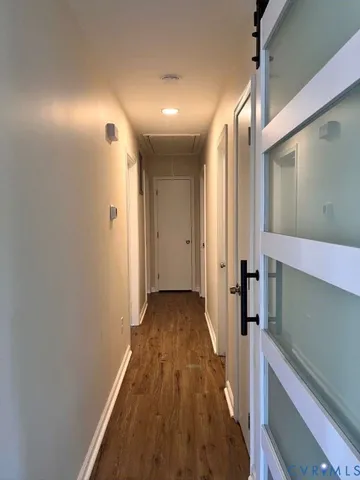 a view of a hallway with wooden floor