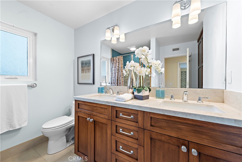 5 High Bluff Laguna Niguel, CA 92677 - Photo 39 of 64 a bathroom with a toilet a double vanity sink and a mirror