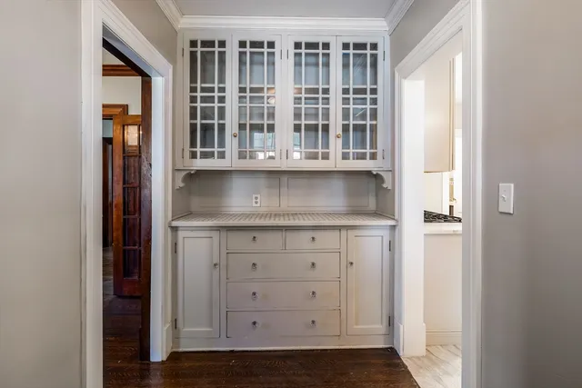 a kitchen with stainless steel appliances granite countertop a refrigerator a sink dishwasher a dining table and chairs with wooden floor