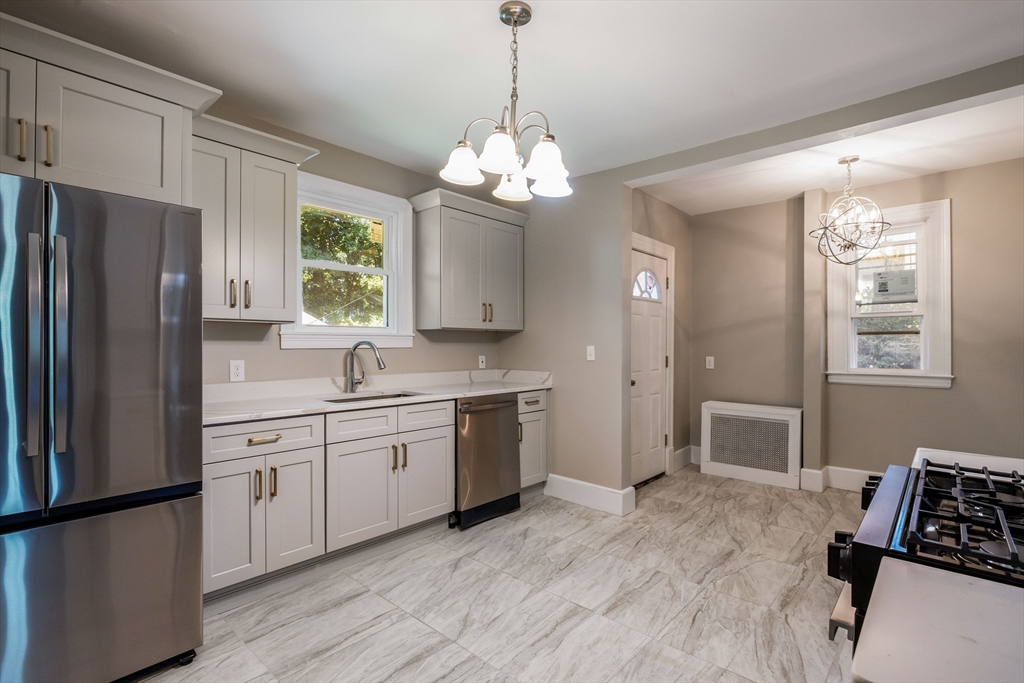 122 Bellevue Avenue Springfield, MA 01108 - Photo 13 of 32 a kitchen with stainless steel appliances granite countertop a refrigerator a sink dishwasher a dining table and chairs with wooden floor