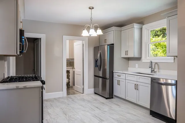 a kitchen with stainless steel appliances a stove a sink and a microwave