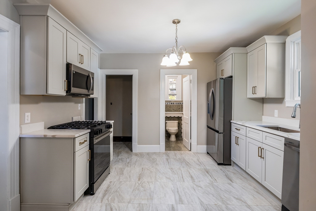122 Bellevue Avenue Springfield, MA 01108 - Photo 18 of 32 a kitchen with stainless steel appliances a stove refrigerator and microwave