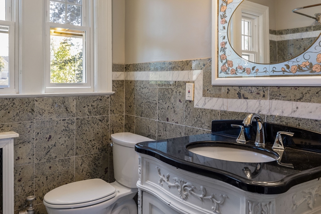 122 Bellevue Avenue Springfield, MA 01108 - Photo 21 of 32 a bathroom with a granite countertop toilet a sink and a mirror