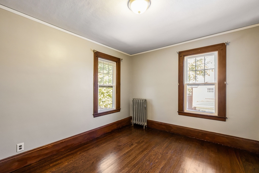 122 Bellevue Avenue Springfield, MA 01108 - Photo 27 of 32 a view of an empty room with wooden floor and a window