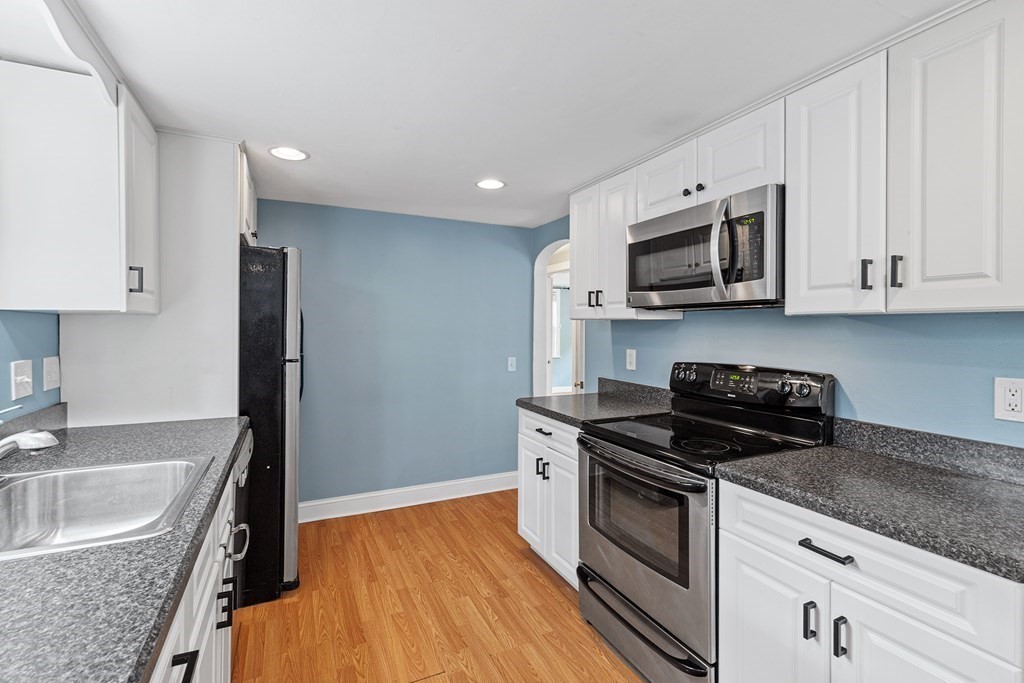 34 Londonderry Road Framingham, MA 01701 - Photo 8 of 33 a kitchen with stainless steel appliances granite countertop a sink dishwasher stove and microwave with wooden floor