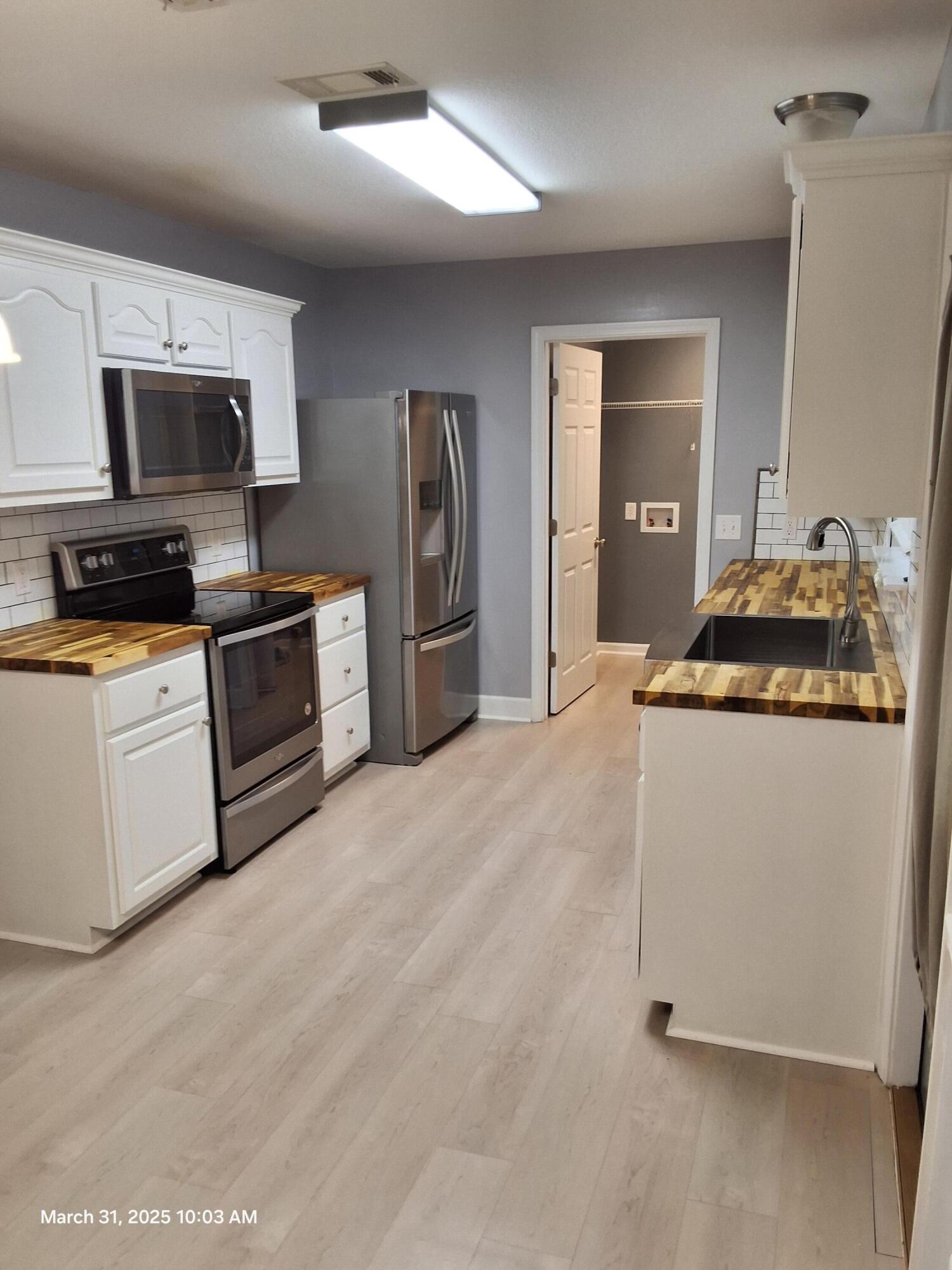 701 Georgia Street Crestview, FL 32536 - Photo 10 of 26 a kitchen with stainless steel appliances granite countertop a stove a sink and a refrigerator