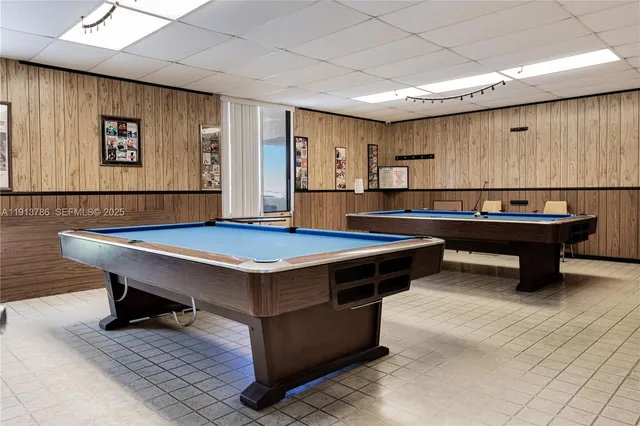 a room with pool table and windows
