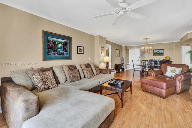 a living room with furniture kitchen view and a wooden floor
