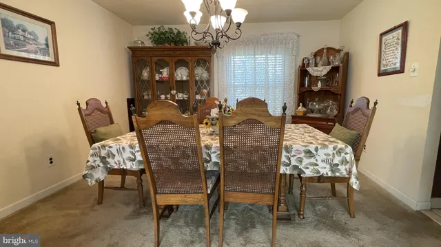 a view of a dining room with furniture and chandelier