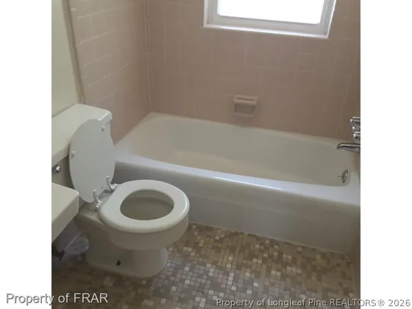 a bathroom with a toilet and a bathtub