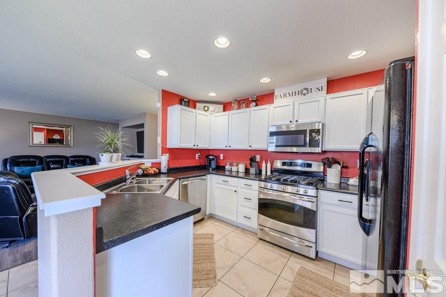 7635 Corso Street Reno, NV 89506 - Photo 9 of 19 a kitchen that has a lot of cabinets in it and stainless steel appliances