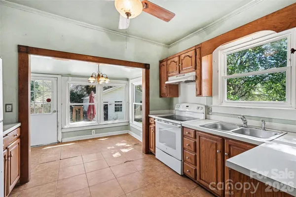 a large kitchen with stainless steel appliances granite countertop a sink and cabinets