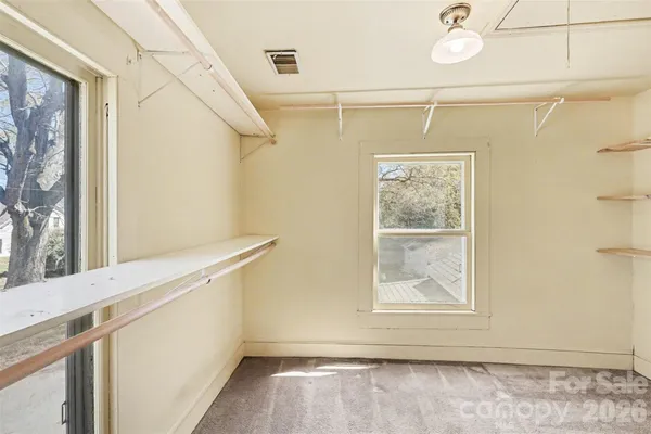 a view of a small space with wooden floor and a window