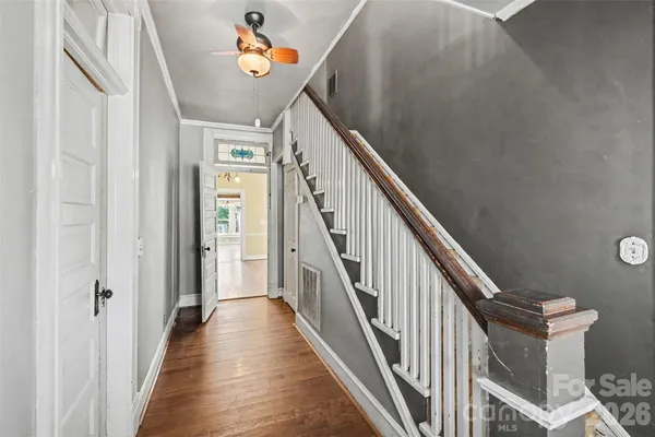 a view of a hallway with wooden floor and stairs