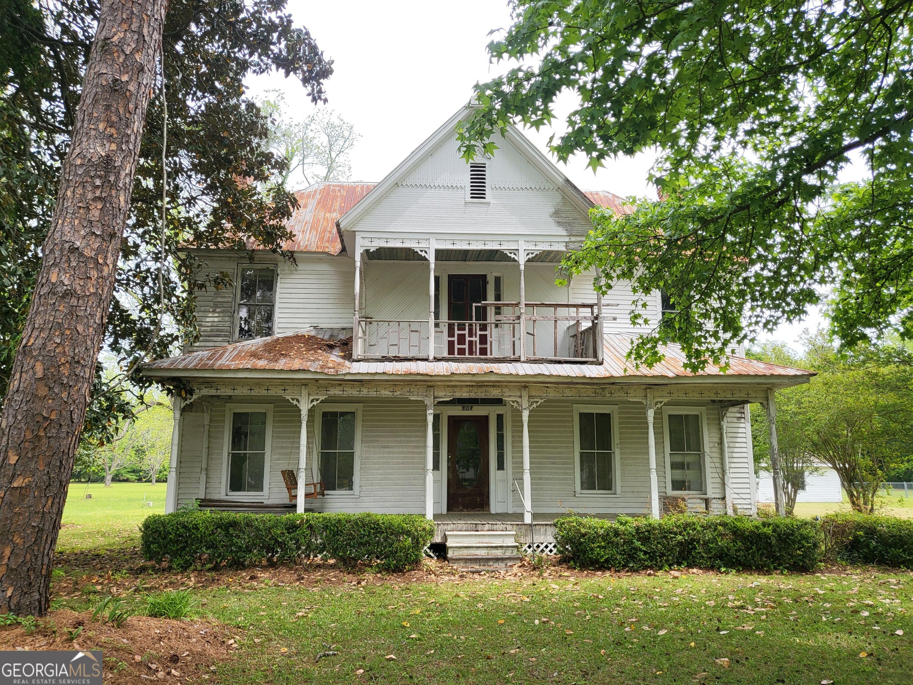 a front view of a house with porch and garden