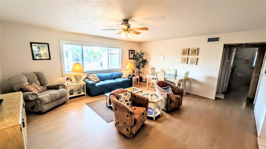 360 Base Avenue East, Unit 424 Venice, FL 34285 - Photo 2 of 20 a living room with furniture and a chandelier