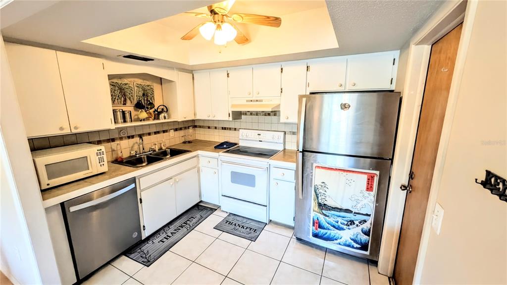 360 Base Avenue East, Unit 424 Venice, FL 34285 - Photo 3 of 20 a kitchen with white cabinets and white appliances