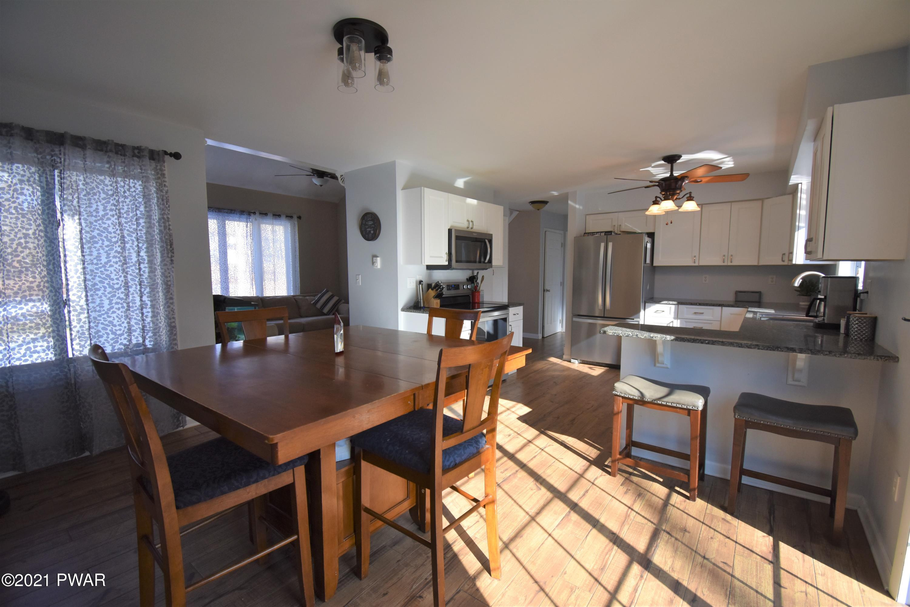 244 Fox Road Dingmans Ferry, PA 18328 - Photo 12 of 31 a kitchen with a dining table chairs and a refrigerator