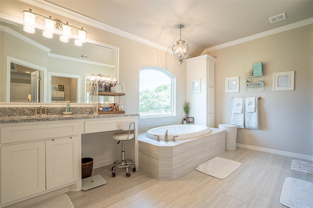 1920 Meander Road Granbury, TX 76049 - Photo 18 of 40 Bathroom featuring a built-in soaking tub with a tiled surround, an arched window, and a chandelier light fixture