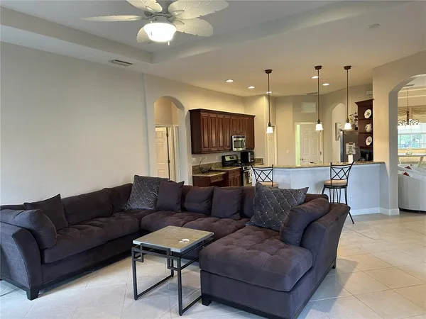 a living room with furniture and a view of kitchen