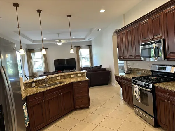 a kitchen with stainless steel appliances granite countertop a stove a sink and a wooden floors