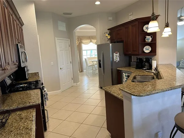 a kitchen with stainless steel appliances granite countertop a sink a stove and a refrigerator