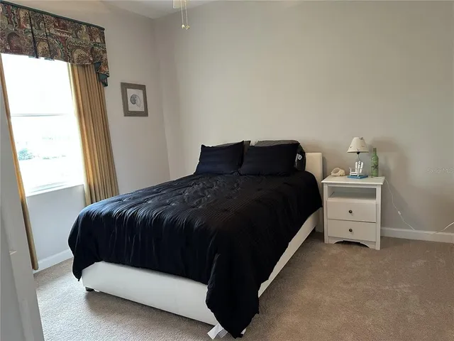 a large bed sitting in a bedroom next to a window