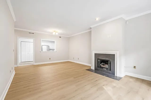 an empty room with fireplace and wooden floor