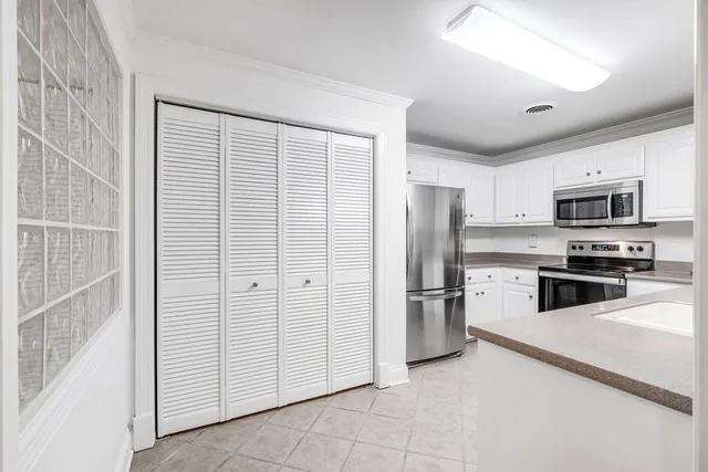 a kitchen with stainless steel appliances and white cabinets