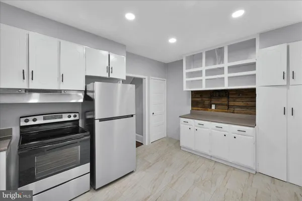 a kitchen with granite countertop a refrigerator stove a sink and dishwasher with wooden floor