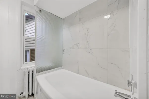 a view of an empty room with wooden floor and windows