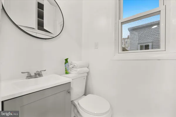 a view of a white house with a small yard and large tree