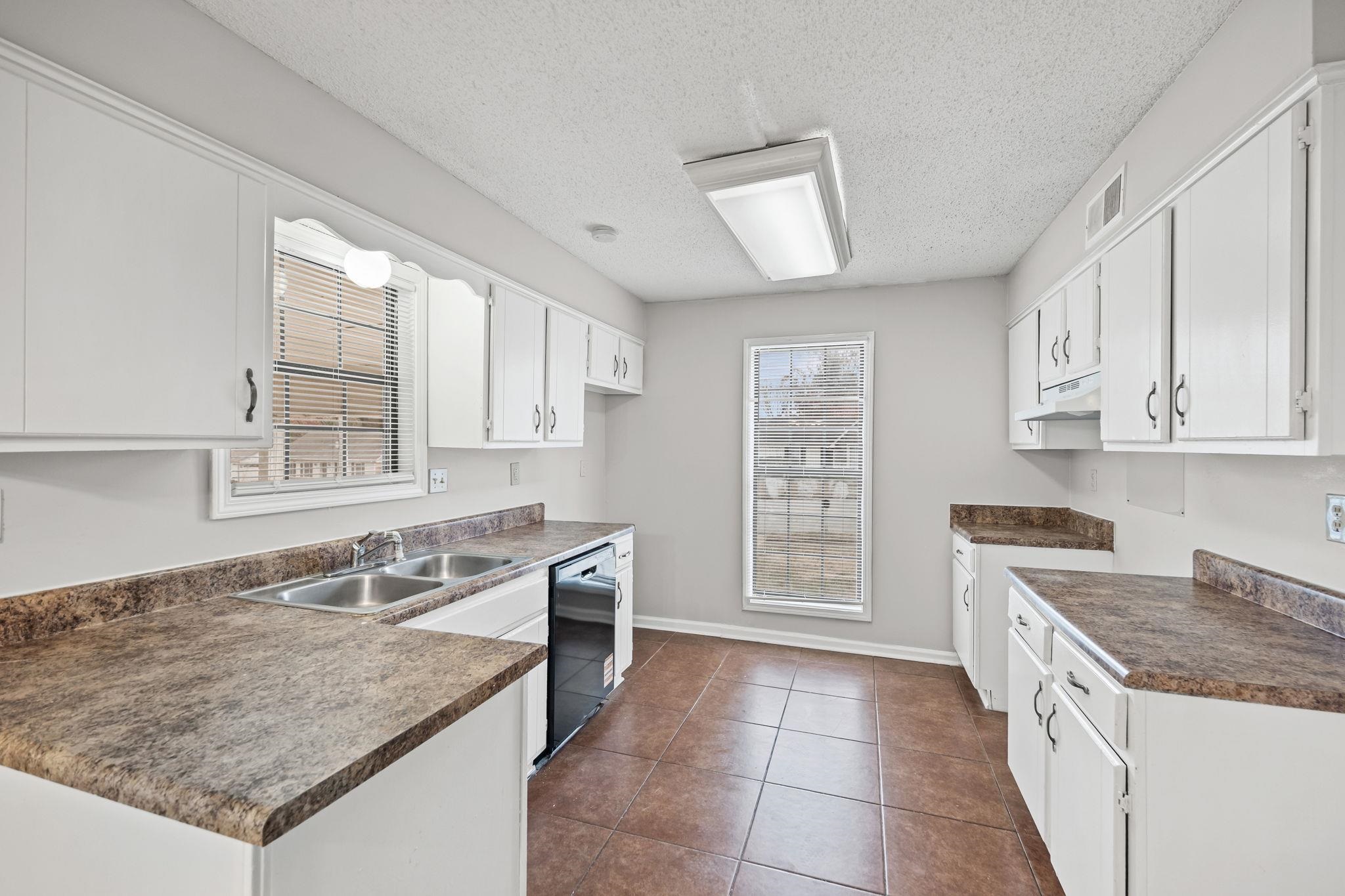 6730 Birch Run Lane Memphis, TN 38115 - Photo 8 of 20 Kitchen with dark countertops, white cabinets, a textured ceiling, and dark tile patterned flooring
