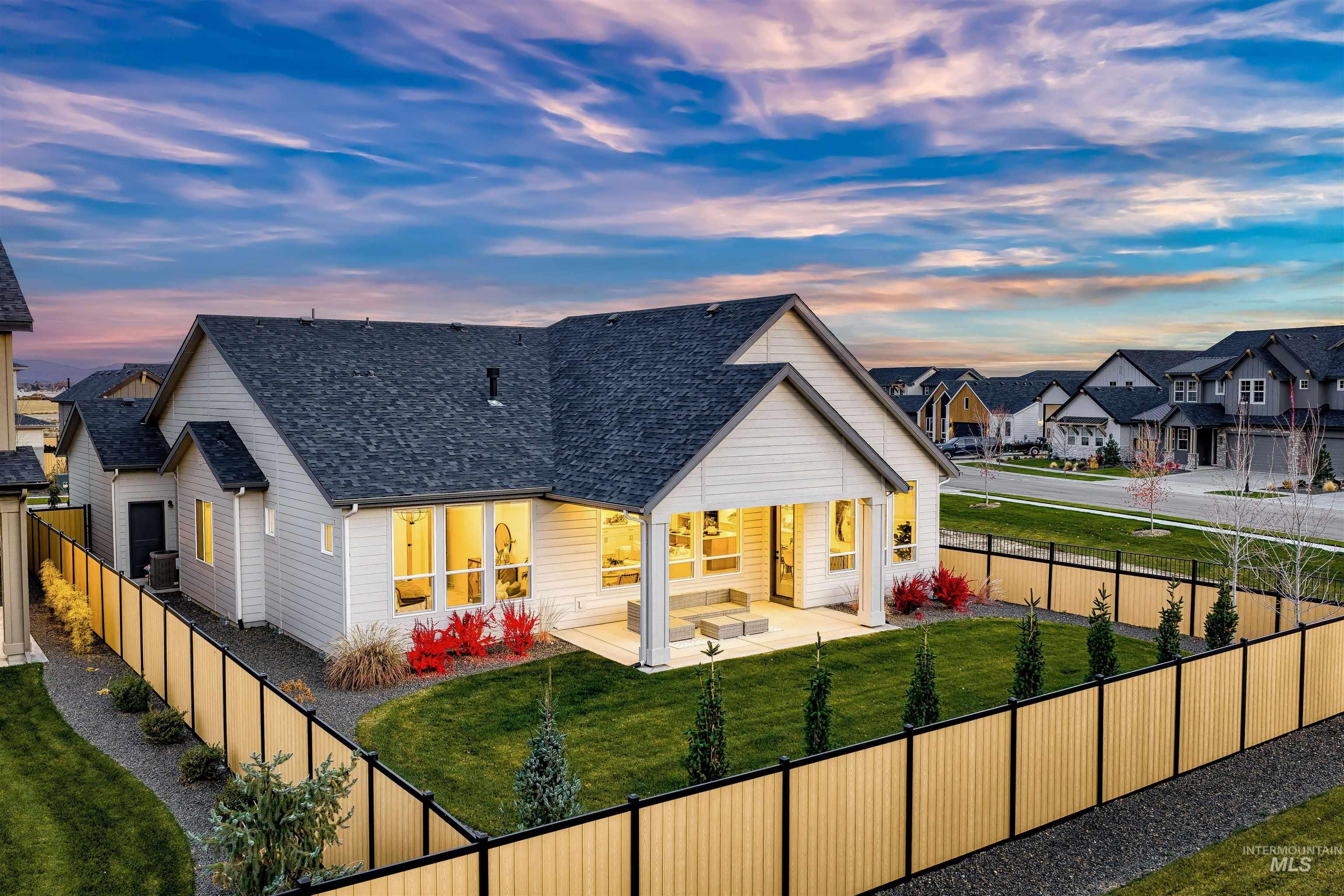 Back of property with a shingled roof, a fenced backyard, a residential view, and a patio