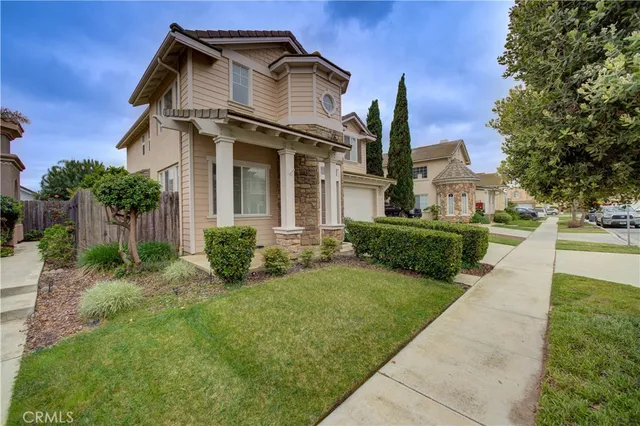 a view of a house with brick walls and a yard with plants
