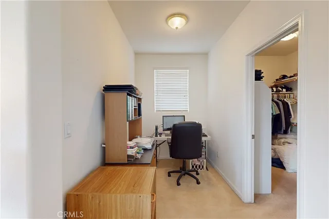 a bedroom with a bed and a computer on a desk