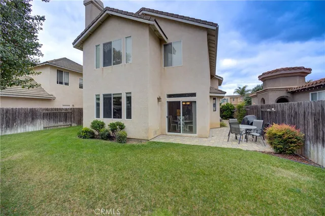 a view of a chair and table in backyard of the house