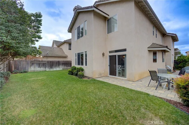 a view of a chair and table in backyard of the house