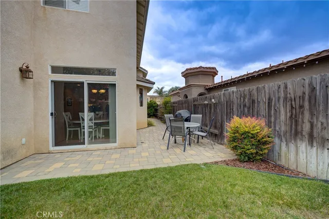 a view of a backyard with large trees and wooden fence