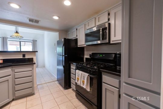 400 Tepatitlan Court Ridgecrest, CA 93555 - Photo 12 of 35 a kitchen with stainless steel appliances granite countertop a stove microwave and refrigerator