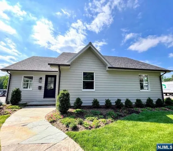 a front view of a house with yard and green space