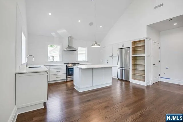 a kitchen with stainless steel appliances cabinets a wooden floor and a sink