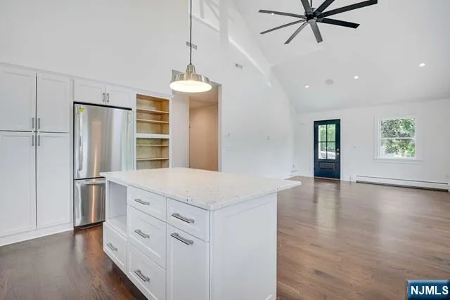 a kitchen with stainless steel appliances a refrigerator and a hard wood floor