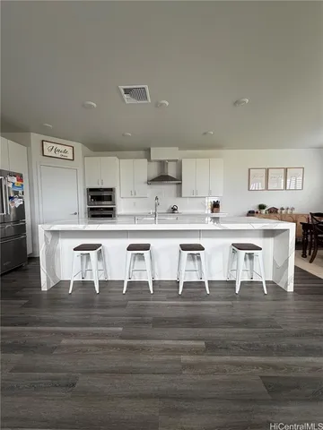 a kitchen with stainless steel appliances kitchen island granite countertop a stove and a cabinets