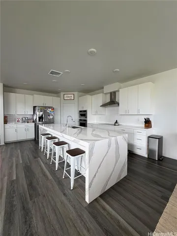 a large white kitchen with lots of counter space and a sink