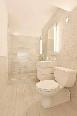 a white toilet sitting next to a bathroom sink